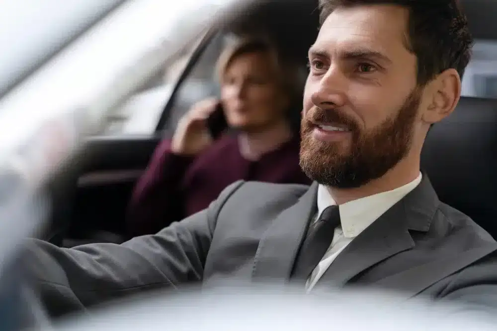 un vtc au volant avec une cliente